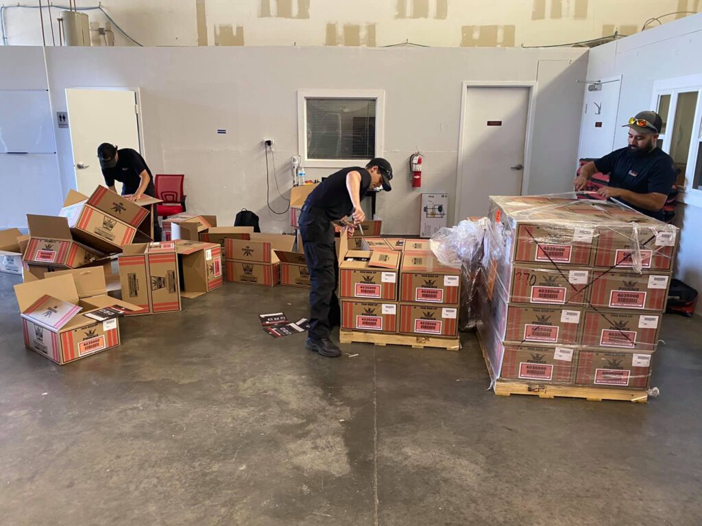 Team members moving boxes of supplies inside a restoration facility