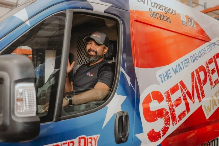 Semper Dry crew member in the cab of a stars and stripes wrapped emergency response van